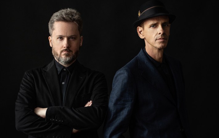 Photo of New York-based synth-pop duo (live they are a five-piece) Dream Prescription showing the two main members wearing dark clothes looking right at you.