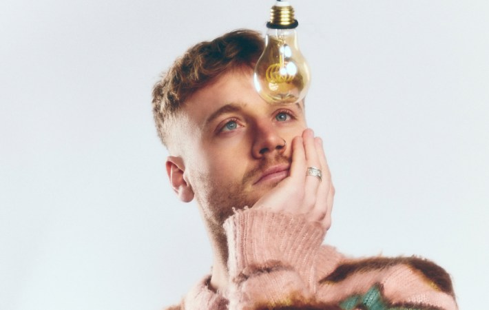 Portrait of Irish singer/songwriter Tadhg Daly staring at a lamp.